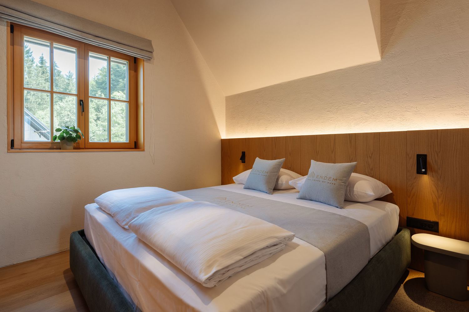 Second bedroom tucked beneath a sloped wood ceiling with framed art above the bed