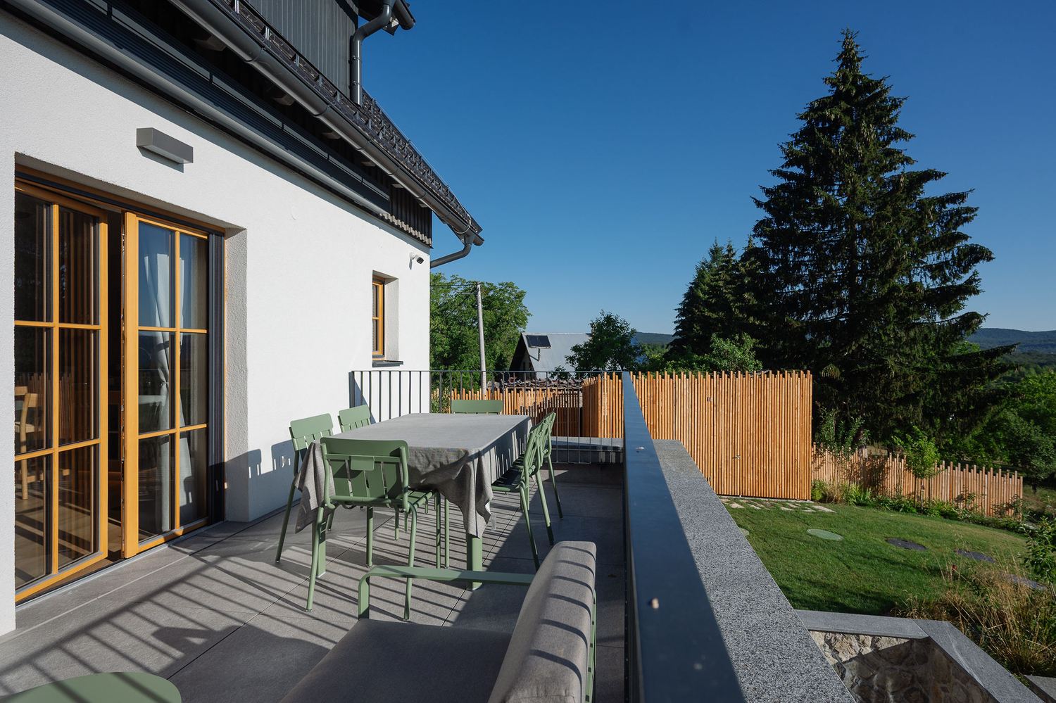 Wood deck with outdoor dining table overlooking the garden
