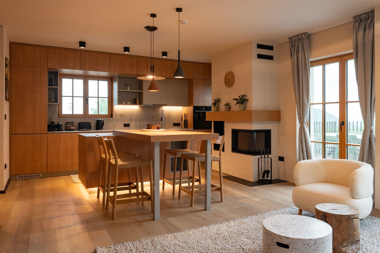 Wood kitchen and dining table set for breakfast beneath pendant lighting