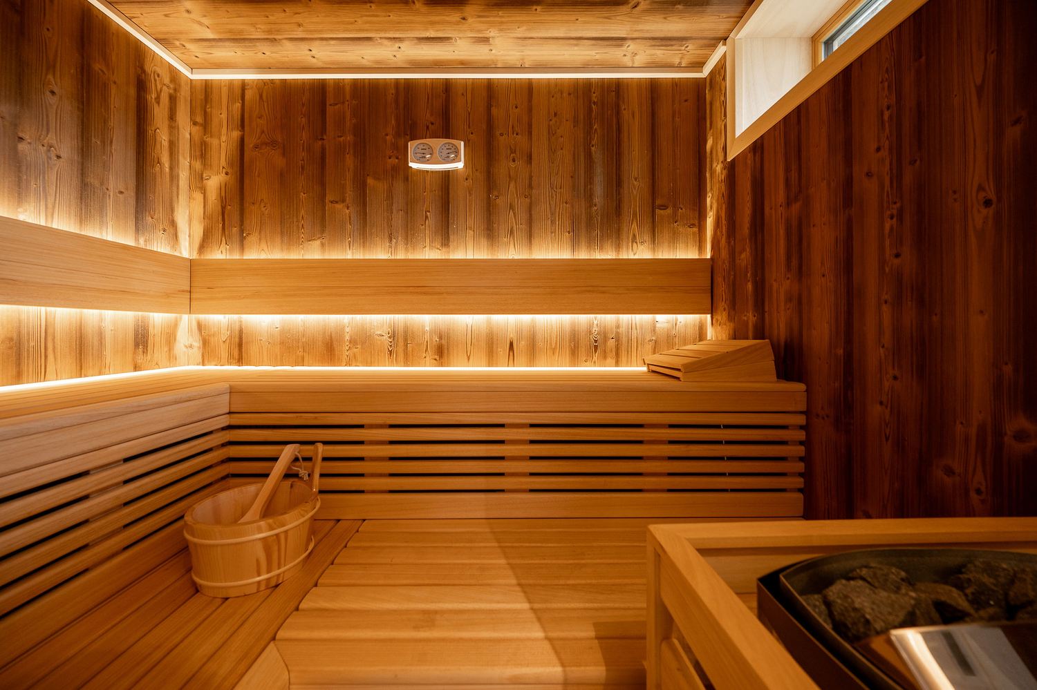 Private wood-lined sauna with warm ambient lighting